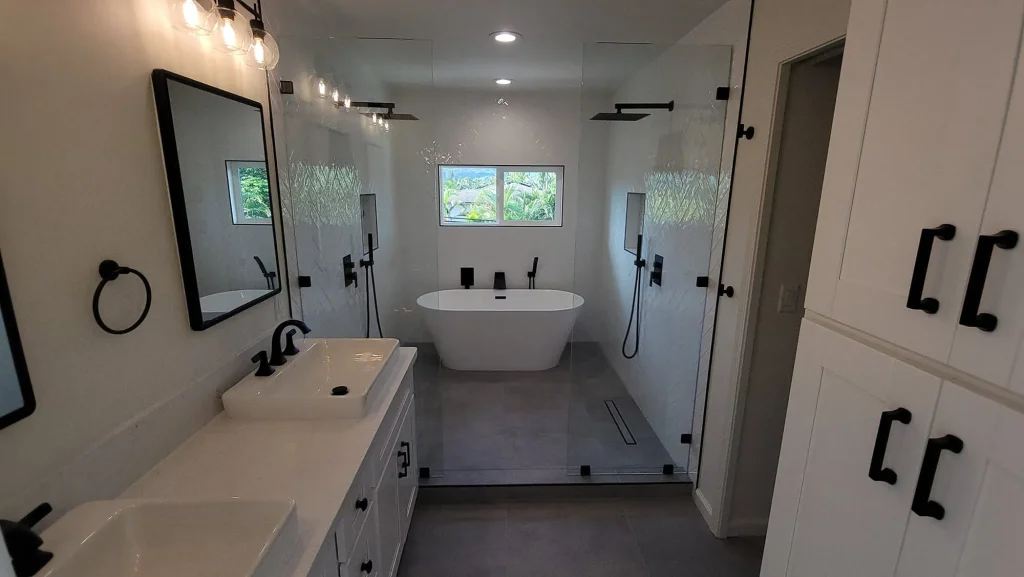 Bathroom with double vanity, freestanding tub and glass-enclosed walk-in shower with matte black fixtures