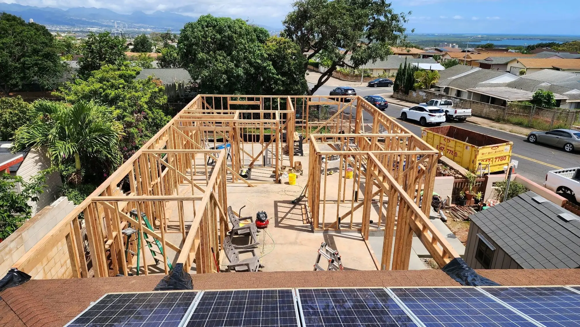 Aerial view of new wall framing on a residential lot with neighborhood and ocean in the distance