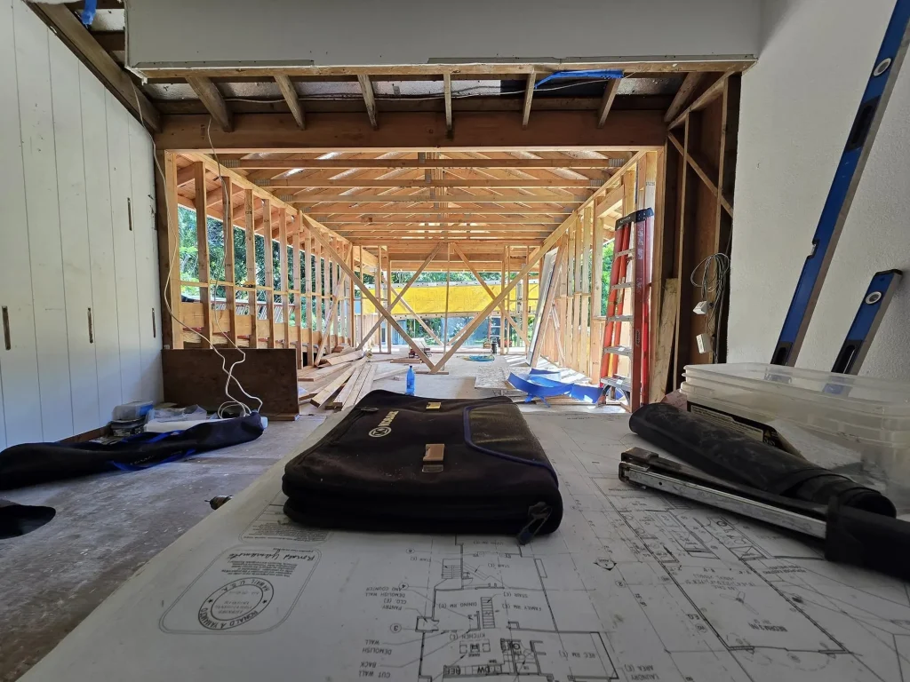 Construction plans laid out on site inside a framed space
